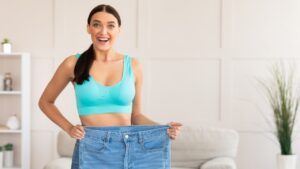 sprueche abnehmen motivation Titelbild Frau die abgenommen hat mit alter zu großer Jeans